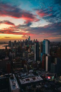 Aerial view of modern buildings against sky during sunset