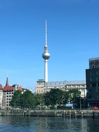 View of communications tower in city against clear sky