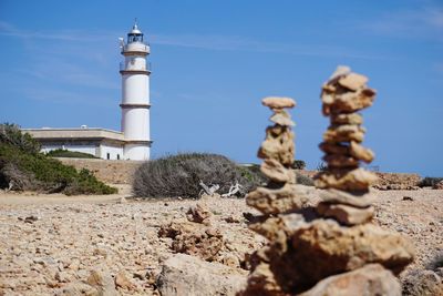 Lighthouse on rock against sky