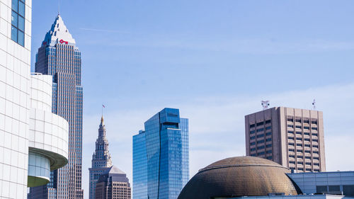 Low angle view of modern buildings against blue sky