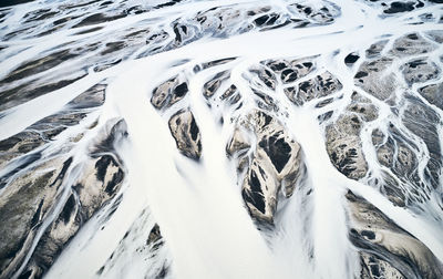 Snow masses covering mountainous land and moving with wind