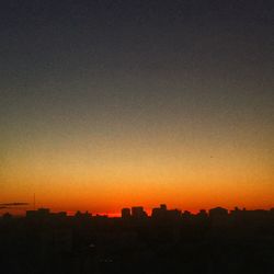 Silhouette buildings against sky during sunset