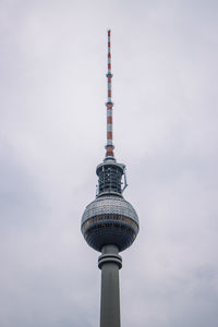 Low angle view of communications tower against sky in city