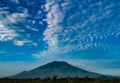 Scenic view of mountains against blue sky