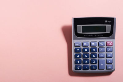 Close-up of calculator against pink background