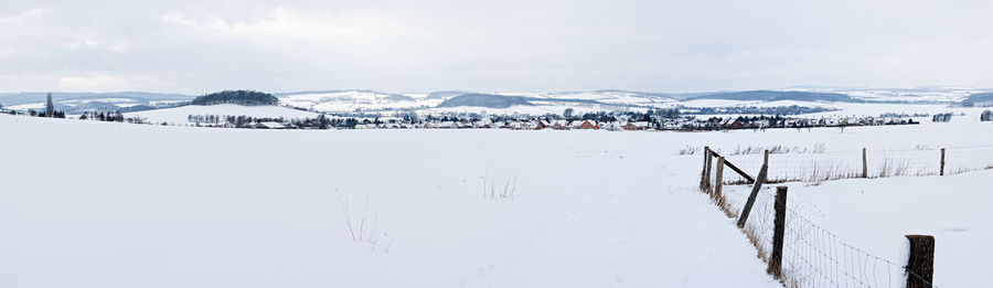 Snow covered landscape against sky