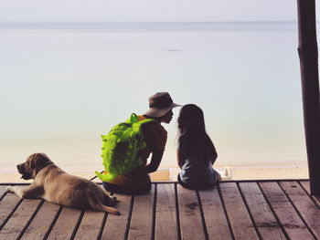 Woman with dog by sea against sky