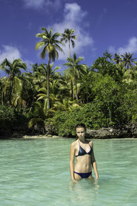 Portrait of young  woman in  lagoon whith tropical trees   in lifou island new caledonia 