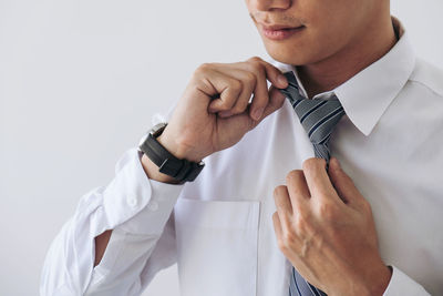 Midsection of businessman wearing necktie against white background