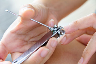 Close-up of woman cutting nails with clipper