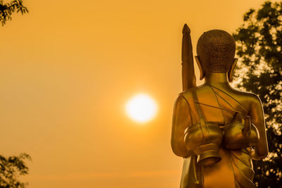 Buddha statue against sky during sunset