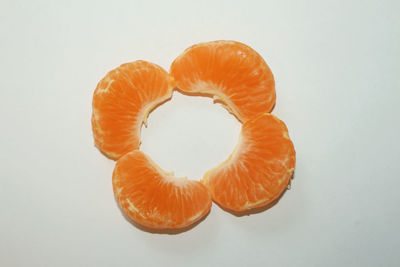 Close-up of orange slice over white background