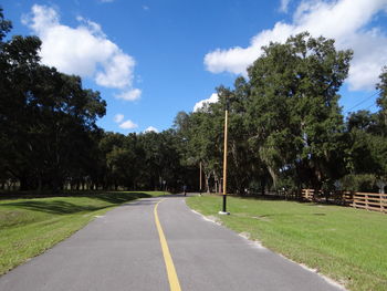 Empty road with trees in background