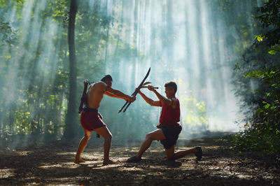 Full length of friends enjoying in forest