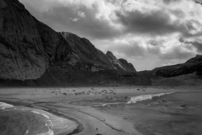 Scenic view of coast and mountains against sky