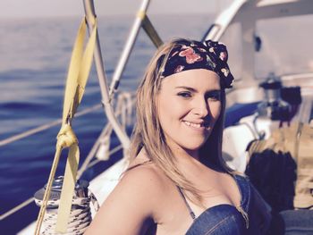 Portrait of smiling beautiful woman on boat in sea