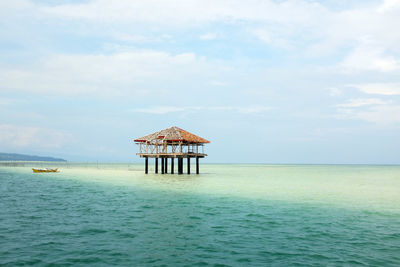 Lifeguard hut in sea against sky