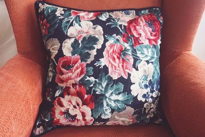 Close-up of floral patterned cushion on armchair at home