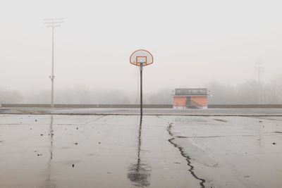 View of basketball hoop on snowy field against clear sky