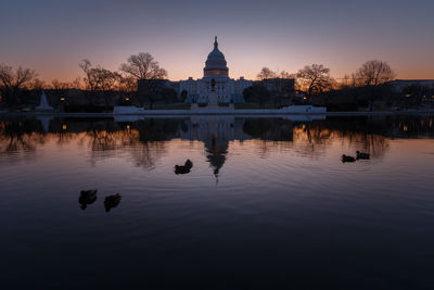 United states capital dome with reflection on river during sunrise