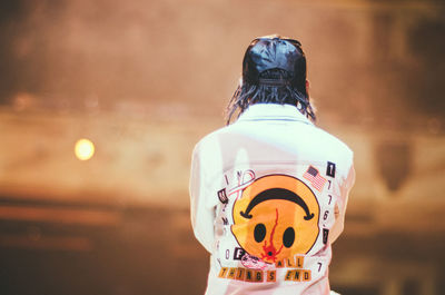 Rear view of man wearing cap and shirt with smiley