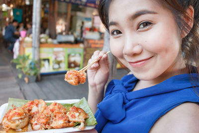 Portrait of smiling woman having food
