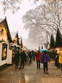 Rear view of people walking on road in winter