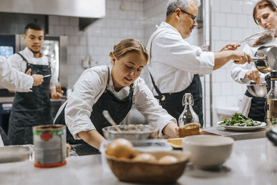 Busy multiracial male and female chefs working in commercial kitchen