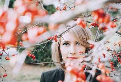 Portrait of beautiful woman with red berries growing on branches