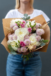 Midsection of woman holding rose bouquet