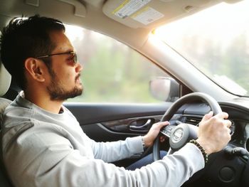 Young man sitting in car