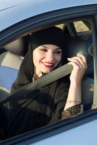 Close-up of smiling woman sitting in car