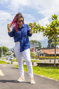 Full length of woman standing against plants