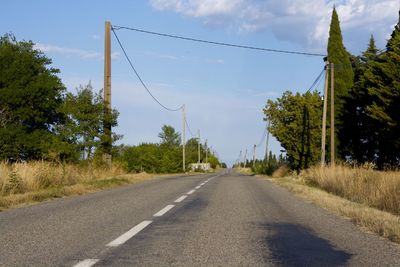 Road amidst trees against sky