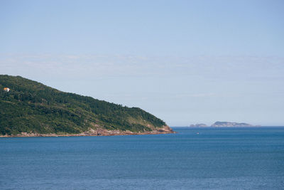 Scenic view of sea and mountains against sky