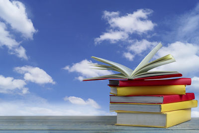 Stack of books on table against sky