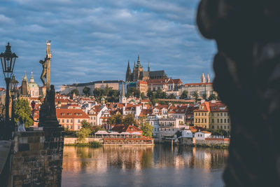 River amidst buildings in city against sky