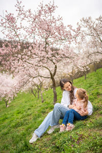 Rear view of woman sitting on grassy field