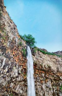 Scenic view of waterfall against sky