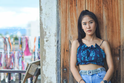 Portrait of beautiful woman standing against wall