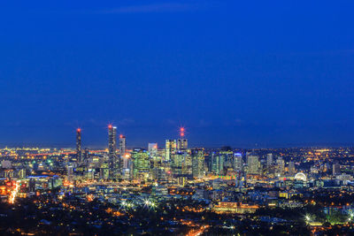 High angle view of illuminated buildings against blue sky