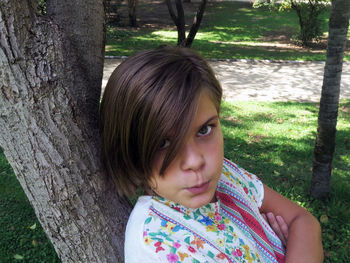 Portrait of girl against tree trunk