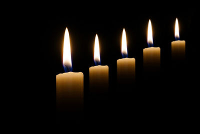 Close-up of candles burning in darkroom