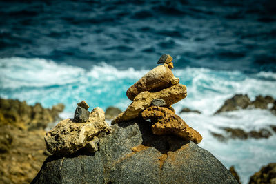 Stack of pebbles on rock at beach