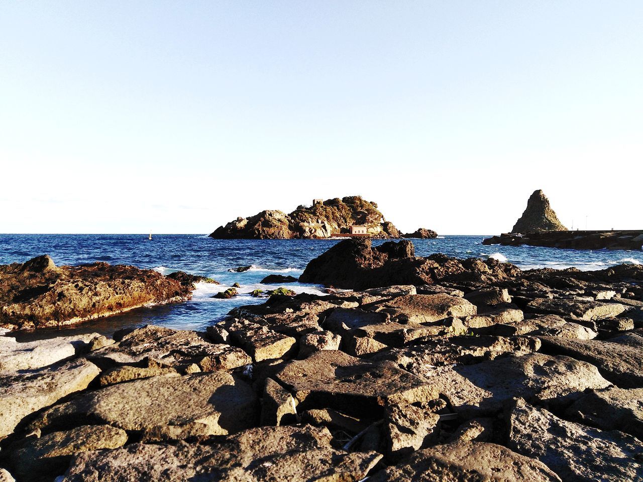 VIEW OF ROCKS ON BEACH AGAINST CLEAR SKY