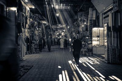 People walking on illuminated street at night