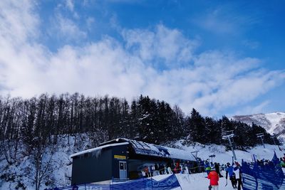 Built structure on snow covered mountain against sky