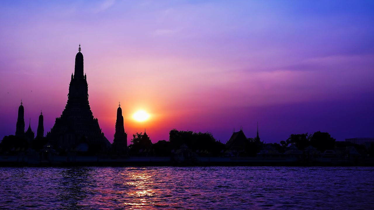 SILHOUETTE TEMPLE AGAINST BUILDINGS DURING SUNSET