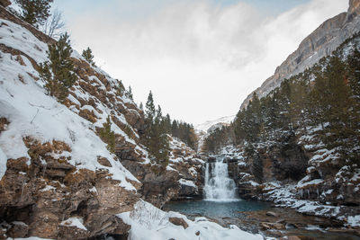 Scenic view of waterfall against sky during winter