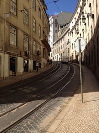 Railroad tracks in city against clear sky